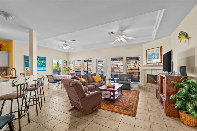 living room featuring a healthy amount of sunlight, a tile fireplace, and light tile patterned floors