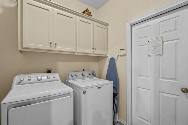 laundry area with washer and clothes dryer and cabinets