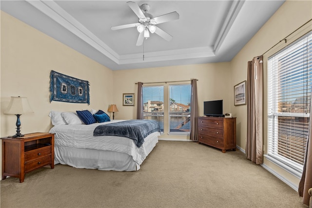 bedroom with ceiling fan, light carpet, and a raised ceiling