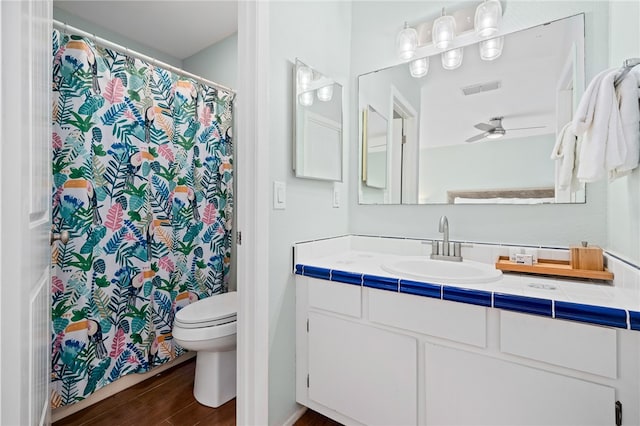 bathroom featuring wood-type flooring, ceiling fan, toilet, and vanity