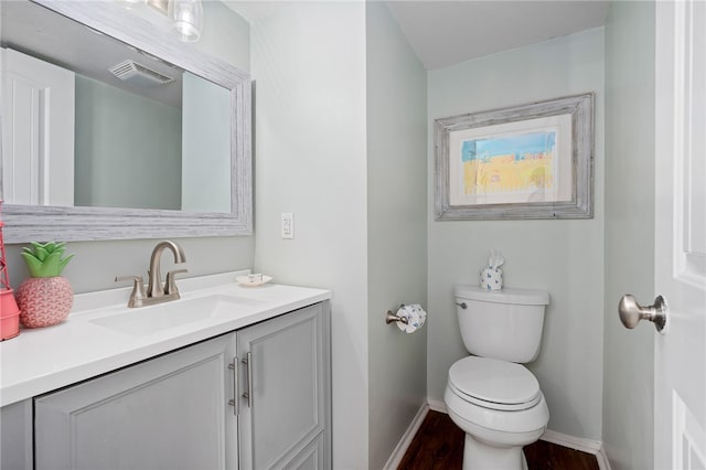 bathroom with hardwood / wood-style floors, vanity, and toilet