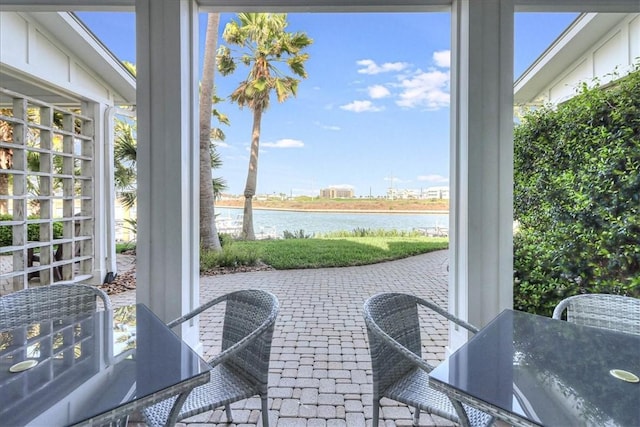 sunroom / solarium featuring a water view