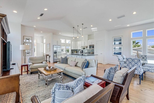 living room featuring lofted ceiling and light wood-type flooring