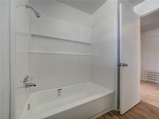 bathroom with wood-type flooring and tiled shower / bath