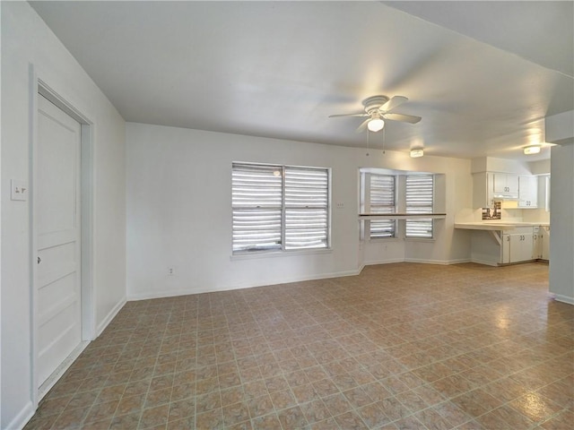 unfurnished living room with ceiling fan