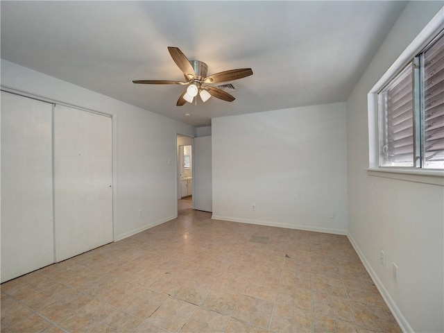 unfurnished bedroom with ceiling fan and a closet