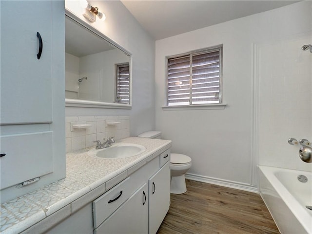 full bathroom with hardwood / wood-style flooring, tasteful backsplash, vanity, bathtub / shower combination, and toilet