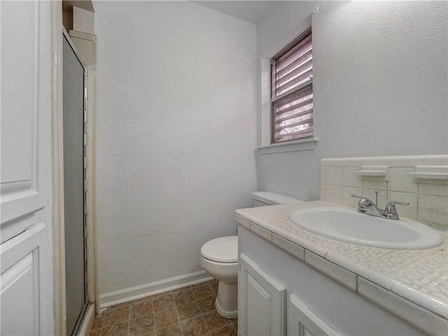 bathroom with tasteful backsplash, vanity, toilet, and walk in shower