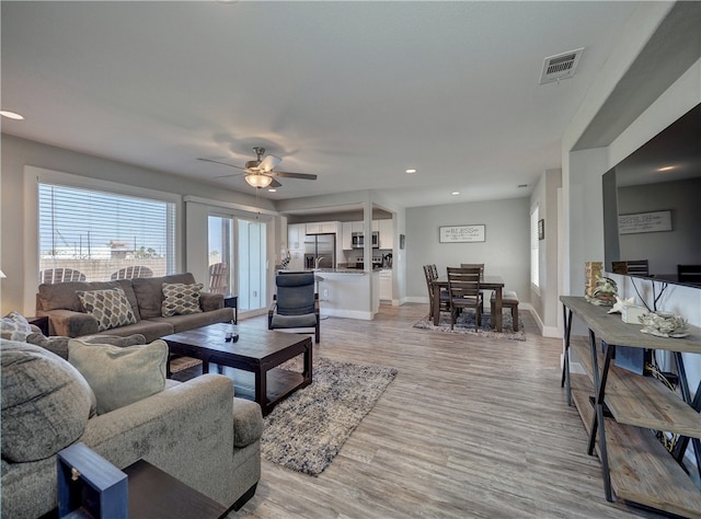 living room with light hardwood / wood-style floors and ceiling fan