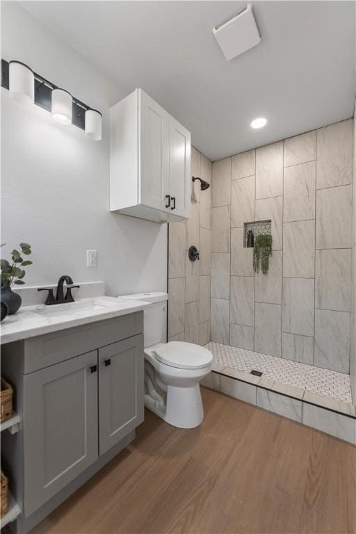2809 Tarlton St, Corpus Christi, TX 78405 - bathroom featuring tiled shower, wood finished floors, vanity, and recessed lighting