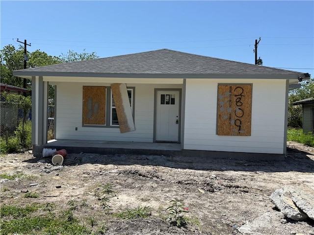 bungalow-style house featuring a porch and roof with shingles