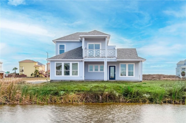 rear view of property with a water view and a balcony