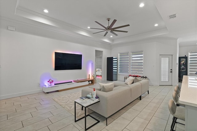 living room with crown molding, ceiling fan, and a raised ceiling