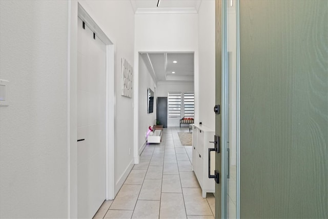 hallway featuring light tile patterned flooring and crown molding