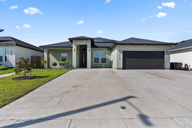 prairie-style house with a garage and a front lawn