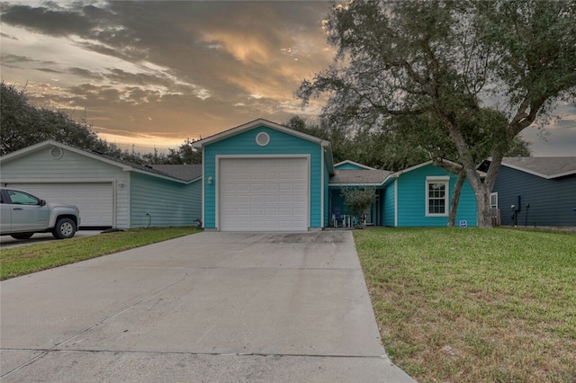 single story home with a garage and a lawn