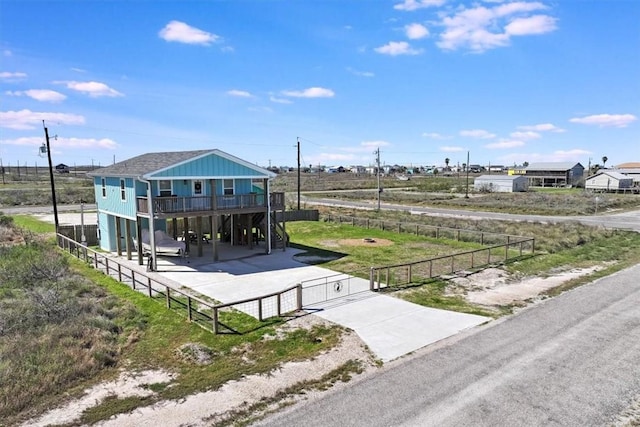 exterior space with a carport, driveway, a fenced front yard, and a gate