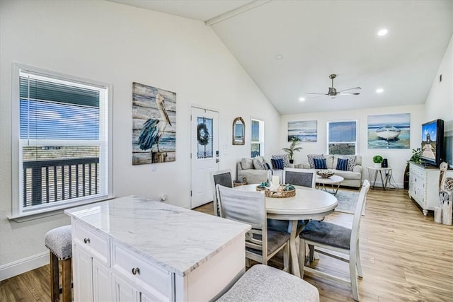 dining room featuring light wood-type flooring, high vaulted ceiling, a ceiling fan, recessed lighting, and baseboards