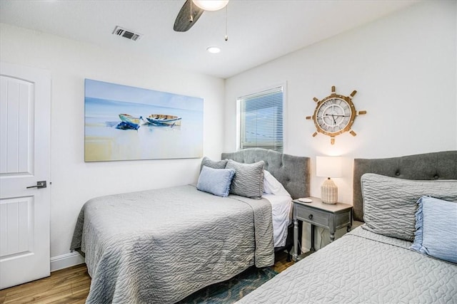 bedroom featuring a ceiling fan, wood finished floors, and visible vents