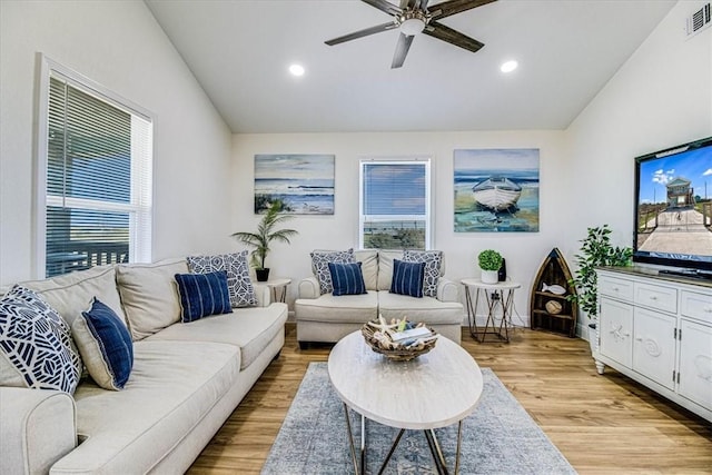 living room with a healthy amount of sunlight, light wood-type flooring, and lofted ceiling