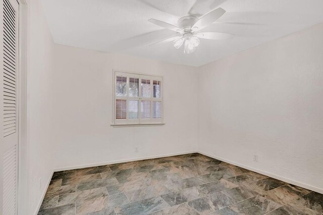 12308 Up River Rd, Corpus Christi, TX 78410 - unfurnished room featuring baseboards, a ceiling fan, and stone finish floors