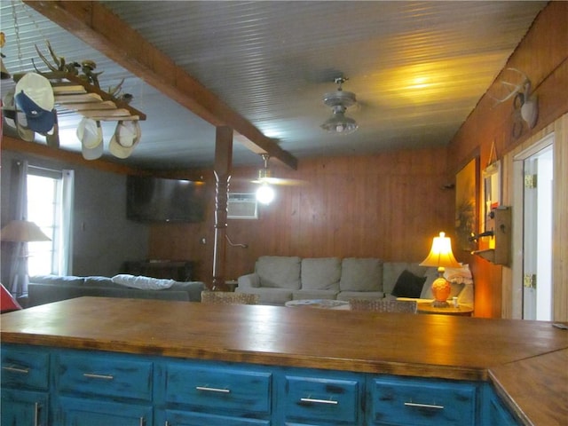 119 Horse Shoe Clf, Sandia, TX 78383 - kitchen with blue cabinets, open floor plan, wood walls, wood counters, and beam ceiling
