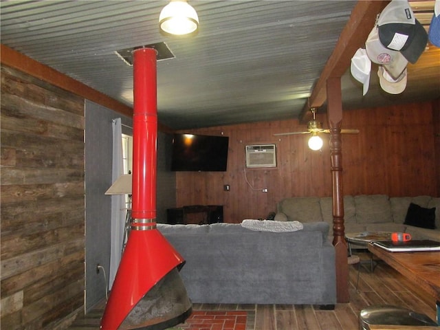 119 Horse Shoe Clf, Sandia, TX 78383 - living area featuring wood walls, a wood stove, and a wall mounted AC