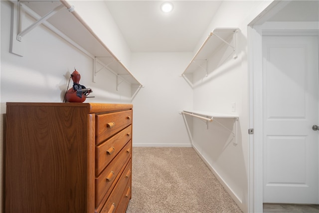 spacious closet featuring light colored carpet