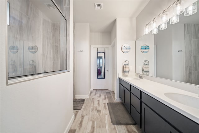 bathroom featuring walk in shower, wood-type flooring, and vanity