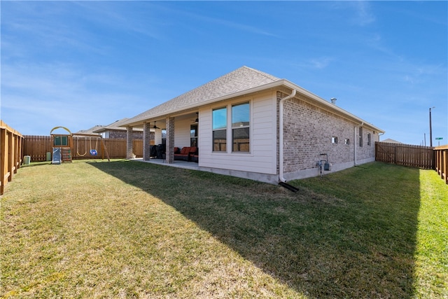 rear view of property with a playground, a patio area, and a lawn