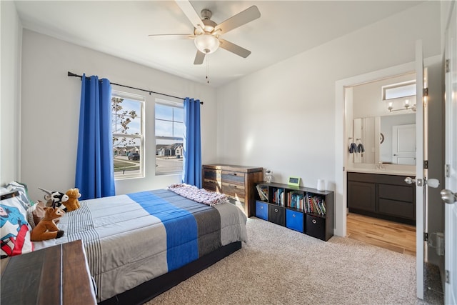 carpeted bedroom featuring ensuite bathroom, sink, and ceiling fan