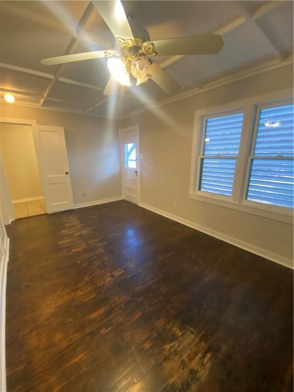 empty room featuring dark wood-type flooring, ceiling fan, and crown molding