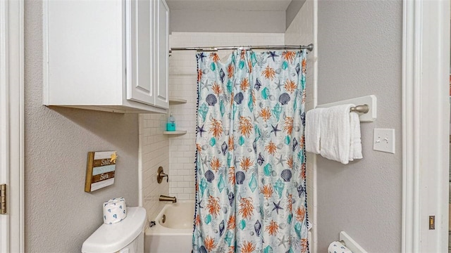 bathroom featuring shower / bath combo with shower curtain and toilet