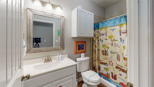 bathroom with toilet, vanity, and walk in shower