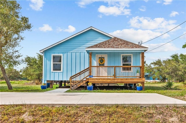 bungalow featuring a porch, roof with shingles, and board and batten siding