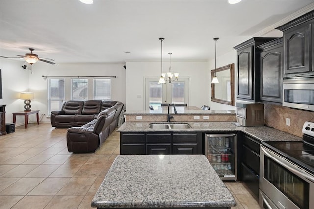 kitchen featuring stainless steel electric range oven, a kitchen island with sink, and sink