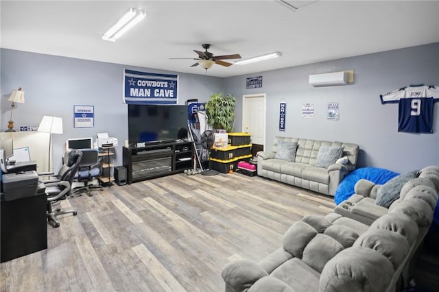 living room with hardwood / wood-style flooring, ceiling fan, and an AC wall unit