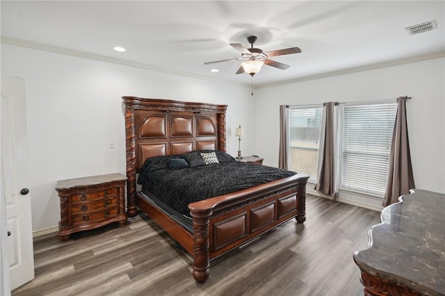 bedroom with dark wood-type flooring, ceiling fan, and crown molding