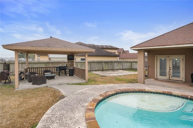 view of swimming pool with a gazebo, a patio area, french doors, and a lawn