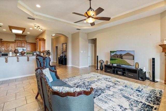 2618 Gentle Wind Ave, Corpus Christi, TX 78414 - living area featuring light tile patterned floors, a raised ceiling, arched walkways, a ceiling fan, and crown molding