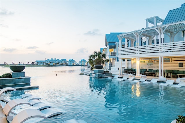 view of swimming pool featuring an outdoor hangout area, a city view, and a pergola