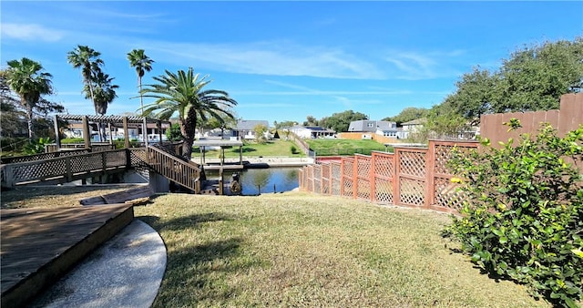 view of dock featuring a pergola, a lawn, fence, and a residential view