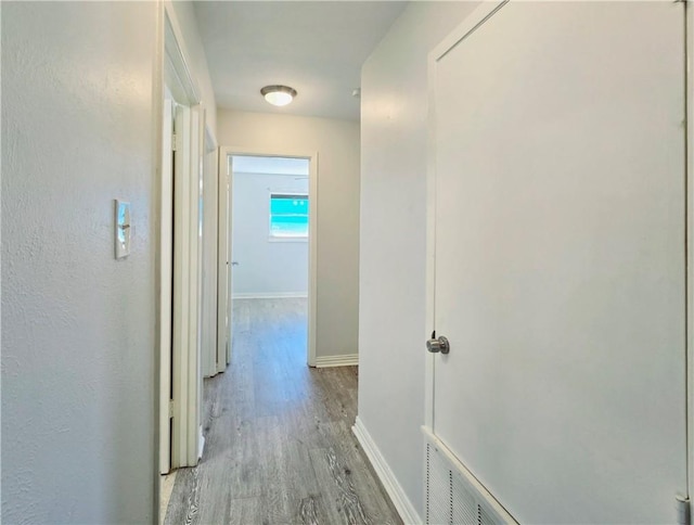 hallway with baseboards and wood finished floors