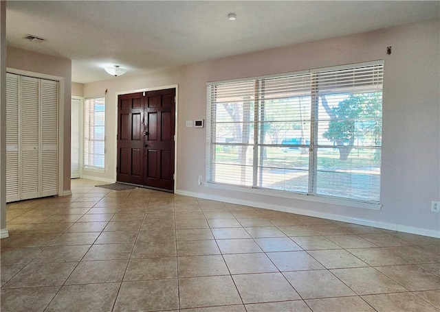 entryway with light tile patterned flooring, baseboards, and visible vents