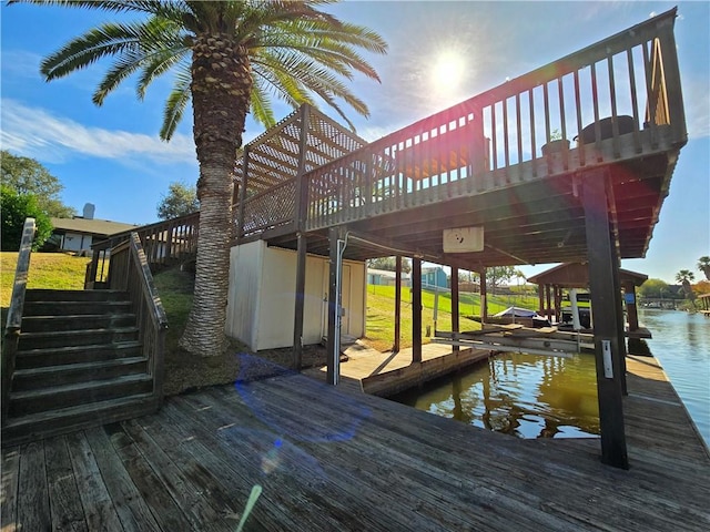 view of dock with boat lift, a water view, and stairs