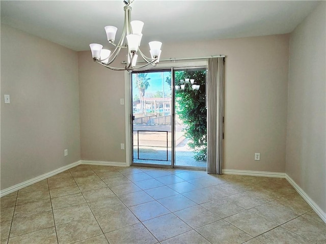 empty room featuring baseboards, light tile patterned floors, and a chandelier