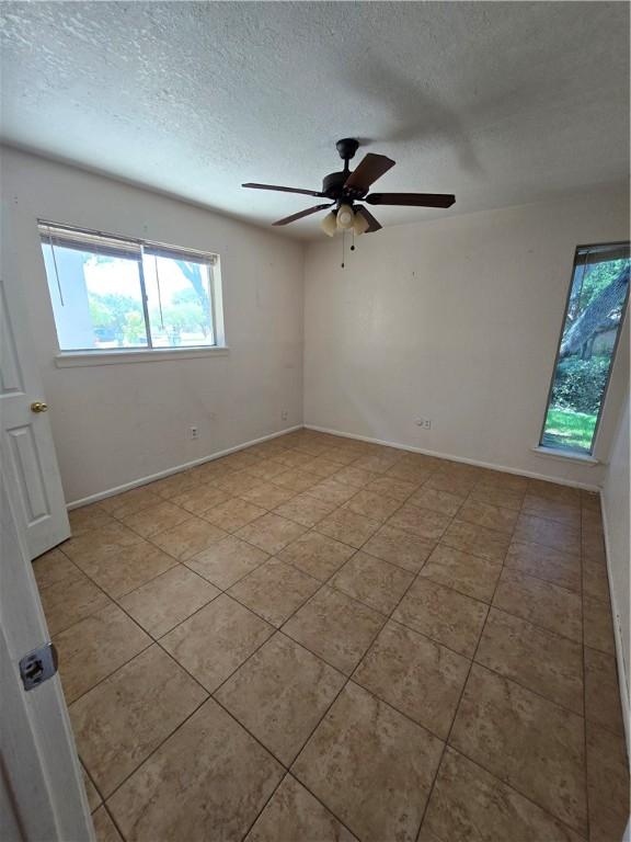 4109 Eagle Dr, Corpus Christi, TX 78413 - tiled empty room featuring plenty of natural light, a textured ceiling, and ceiling fan