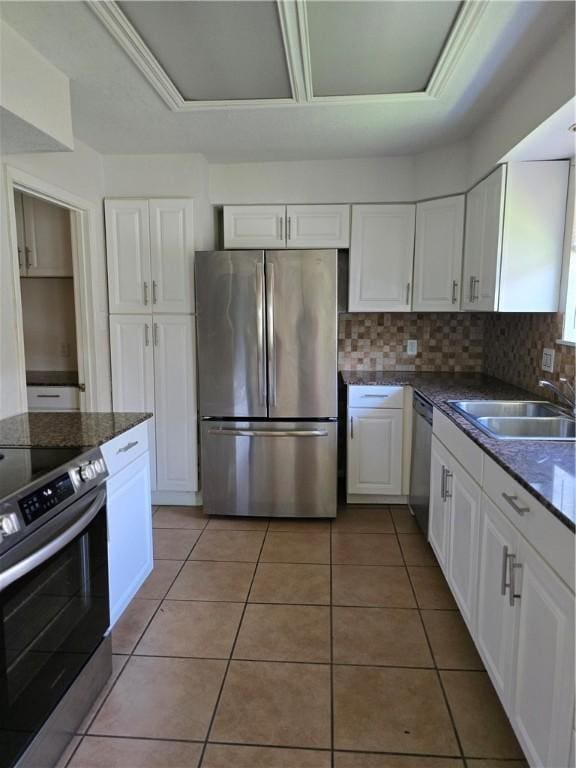 4109 Eagle Dr, Corpus Christi, TX 78413 - kitchen with stainless steel appliances, white cabinetry, light tile patterned floors, and backsplash