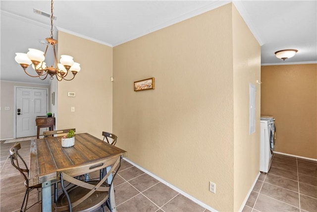 1182 Lee Rd, Aransas Pass, TX 78336 - tiled dining room featuring washing machine and dryer, crown molding, and a chandelier