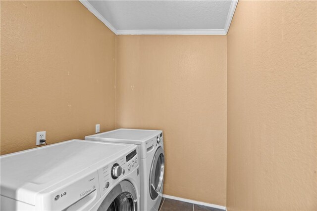 1182 Lee Rd, Aransas Pass, TX 78336 - laundry area featuring washing machine and clothes dryer, ornamental molding, and dark tile patterned flooring